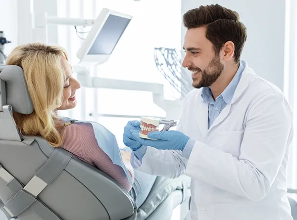 Dentist Austin TX Dentist Explaining Treatment With Tooth Model