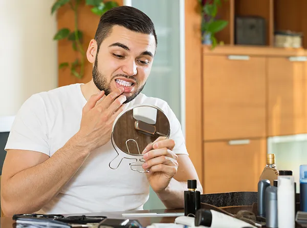 Dentistry Austin TX Man Examining Teeth Closeup Mirror